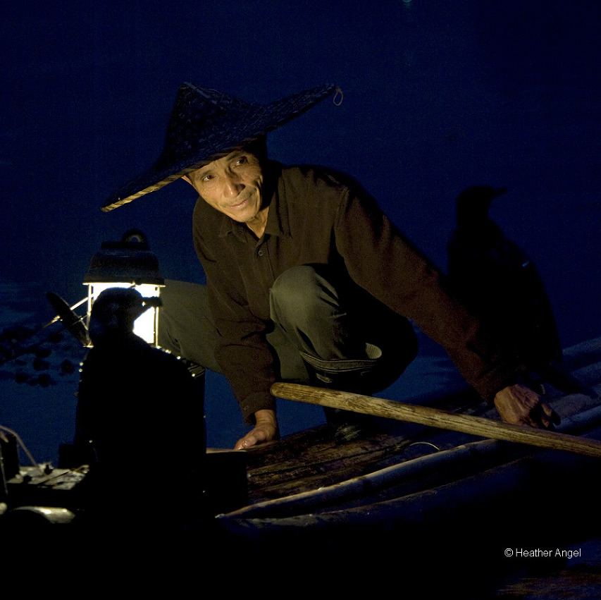 Cormorant fisherman lit by the light of his hurricane lamp on the Lijiang, China